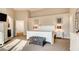 Bright main bedroom suite featuring neutral walls, carpet floors and a decorative chest in front of the bed at 1513 Ravanusa Dr, Henderson, NV 89052