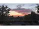 Sunset view of mature landscaping, city views and colorful sky at 1513 Ravanusa Dr, Henderson, NV 89052