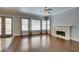 Living room featuring a fireplace, hardwood floors, and large windows with wooden blinds and decorative drapes at 1813 Francisco Peak Pl, Las Vegas, NV 89128