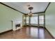 Bright living room featuring a fireplace, hardwood floors, elegant chandelier, and large windows with wooden blinds at 1813 Francisco Peak Pl, Las Vegas, NV 89128