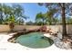 Swimming pool with rock waterfall feature and lush landscaping at 1813 Francisco Peak Pl, Las Vegas, NV 89128