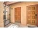 Inviting entryway with a decorative iron gate and two wood doors, offering privacy and charm at 1857 Arbol Verde Way, Las Vegas, NV 89119