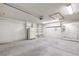Open garage space with a large door, shelving units, and ample room for storage at 1857 Arbol Verde Way, Las Vegas, NV 89119