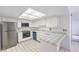 Well-lit kitchen with stainless steel appliances, white cabinets, and tile countertops at 1857 Arbol Verde Way, Las Vegas, NV 89119
