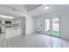 Bright living room with white-tiled floor, kitchen counter, and sliding glass doors to patio at 1857 Arbol Verde Way, Las Vegas, NV 89119