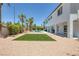 Large backyard featuring turf, gravel, covered patio, and lush palm trees at 2209 Purple Majesty Ct, Las Vegas, NV 89117