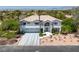 Attractive two-story house with a tile roof, three-car garage, and desert landscaping at 2209 Purple Majesty Ct, Las Vegas, NV 89117