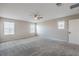 Bedroom with a ceiling fan, neutral walls, carpet flooring, and two windows at 3164 Bormida Ave, Henderson, NV 89044