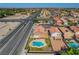 Expansive aerial view of a home showcasing a private pool and a neighborhood with easy access to the highway at 3937 Country Lights St, Las Vegas, NV 89129
