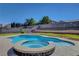Inviting backyard features a freeform pool and elevated spa surrounded by lush landscaping at 3937 Country Lights St, Las Vegas, NV 89129