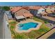 Aerial view of a backyard with a pool, spa, covered patio, and ample green space at 3937 Country Lights St, Las Vegas, NV 89129
