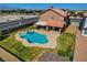 Aerial view of the private backyard featuring a custom pool, spa, covered patio, and well-manicured lawn at 3937 Country Lights St, Las Vegas, NV 89129