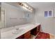Spacious bathroom with dual sinks, vanity lighting and a large mirror at 3937 Country Lights St, Las Vegas, NV 89129