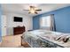 Comfortable bedroom with a large window, ceiling fan, dresser and television at 3937 Country Lights St, Las Vegas, NV 89129
