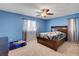 Comfortable bedroom with a large window, ceiling fan and a stylish wood-framed bed at 3937 Country Lights St, Las Vegas, NV 89129