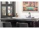 Close up of wet bar with black cabinetry, a modern sink, and display cabinets at 4 Via Vittorio Pl, Henderson, NV 89011