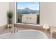 Luxurious bathroom featuring a soaking tub and a picturesque mountain view from the large window at 4 Via Vittorio Pl, Henderson, NV 89011
