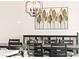 Dining room featuring dark wood table, modern chandelier and leaf-themed wall art at 4 Via Vittorio Pl, Henderson, NV 89011