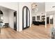 Bright entryway featuring an elegant chandelier, hardwood floors, bar, and a staircase at 4 Via Vittorio Pl, Henderson, NV 89011