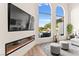 A bright living room with a sleek fireplace, large TV, and window view of the pool at 4 Via Vittorio Pl, Henderson, NV 89011