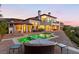 Luxury home exterior with a private pool, patio, and lush landscaping at dusk at 4 Via Vittorio Pl, Henderson, NV 89011