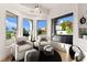 Bright sitting area features white chairs, ottomans, and many windows providing great views at 4 Via Vittorio Pl, Henderson, NV 89011