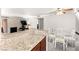 Bright living room featuring a fireplace, dining area with modern table set, and granite counters in the kitchen at 4050 Pacific Harbors Dr # 127, Las Vegas, NV 89121