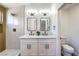 Modern bathroom featuring a double vanity, quartz countertop, and a walk-in shower with bright, white tile surround at 410 Aloha Dr, Henderson, NV 89015