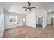 Bright living room featuring wood-look floors, fresh white paint, stylish ceiling fan, and large window at 410 Aloha Dr, Henderson, NV 89015