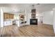 Open-concept living room featuring a fireplace, modern light fixture, and a bright kitchen with stainless appliances at 410 Aloha Dr, Henderson, NV 89015