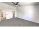Spacious main bedroom with carpet, a ceiling fan, and doors to the bathroom and closet at 410 Aloha Dr, Henderson, NV 89015