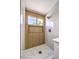 Bright, naturally lit shower with marble tile, wood paneled accent wall and modern fixtures at 410 Aloha Dr, Henderson, NV 89015