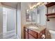 Bathroom vanity with granite counters, wood cabinets, and a decorative mirror at 4212 Estaban Ct, Las Vegas, NV 89110