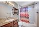 Bathroom with granite counters, wood cabinets, tile bathtub, and a decorative shower curtain at 4212 Estaban Ct, Las Vegas, NV 89110