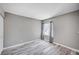 A neutral-painted bedroom has wood-look floors and a window with decorative drapes at 4212 Estaban Ct, Las Vegas, NV 89110