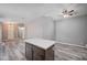 Stylish kitchen island with modern cabinets and a ceiling fan, seamlessly blending the kitchen and living areas at 4212 Estaban Ct, Las Vegas, NV 89110