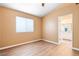 Inviting bedroom featuring wood-look floors, a window for natural light, and a doorway to an adjacent bathroom at 4314 Flaming Ridge Trl, Las Vegas, NV 89147