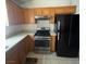 The kitchen has stainless-steel appliances, solid countertops, and oak cabinetry with a black refrigerator at 4314 Flaming Ridge Trl, Las Vegas, NV 89147
