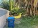 View of a side yard area with mature plants and a blue trash container at 4928 E Philadelphia Ave, Las Vegas, NV 89104