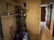 Utility room featuring hot water heater, storage shelves, and a glimpse into the hall at 4928 E Philadelphia Ave, Las Vegas, NV 89104