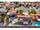 Aerial view showcasing a home with a terra cotta roof, solar panels, a pool, and desert landscaping at 5417 Bible Cir, North Las Vegas, NV 89031