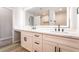 Bathroom featuring dual vanity with marble countertop, white cabinets, and a lighted mirror at 5417 Bible Cir, North Las Vegas, NV 89031