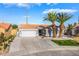 Charming single-story home featuring a two-car garage, desert landscaping, and lush palm trees at 5417 Bible Cir, North Las Vegas, NV 89031