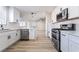 Open-concept kitchen featuring stainless steel appliances, white cabinets and convenient access to the living room at 5417 Bible Cir, North Las Vegas, NV 89031