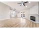 Open-concept living room featuring wood-look floors, a ceiling fan, modern fireplace and lots of natural light at 5417 Bible Cir, North Las Vegas, NV 89031