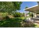 Lush green backyard featuring mature trees and a covered patio area at 5515 N Campbell Rd, Las Vegas, NV 89149