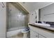 Well-lit bathroom featuring white cabinets, granite counters, and a glass enclosed shower and tub combination at 5515 N Campbell Rd, Las Vegas, NV 89149