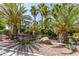 Charming home with a beautifully landscaped yard, including mature palm trees and decorative rock features at 5515 N Campbell Rd, Las Vegas, NV 89149