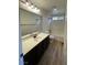Bathroom features single sink vanity with dark wood cabinets and tub shower combo at 5709 Nobleton Ct, North Las Vegas, NV 89081