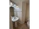 Well-lit half bathroom with pedestal sink, large mirror, and tile flooring at 577 Leap Frog Ave, Las Vegas, NV 89183